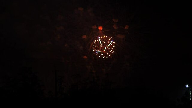 Silver red pink sparks scattering fireworks on the black night sky. General plan