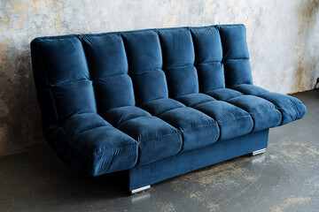 A vibrant blue couch is displayed prominently in a room adjacent to a wall