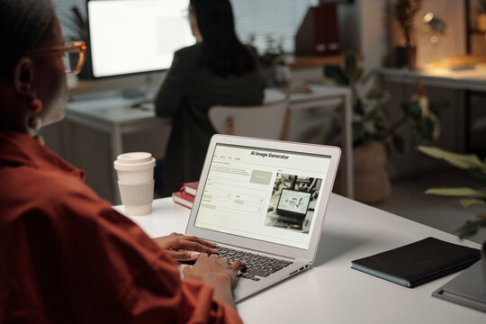 Young female office worker touching keys of laptop keypad with AI image generator and description of content on screen