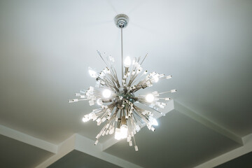 A stunning and beautifully designed chandelier gracefully hangs from the ceiling, adding an...