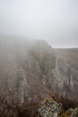 Fog descending on the steep cliffs of tureni's gorges, creating a mysterious and evocative atmosphere in cluj county, romania