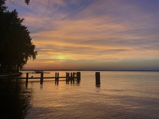 Obraz premium peaceful sunset over lake with reflection in water with dock