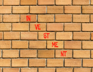 Investment symbol. Concept word Investment on beautiful brown bricks. Beautiful brown brick wall...
