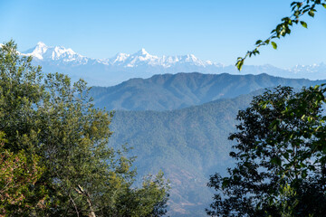 A picturesque view of snow-capped Himalayan peaks including Mt.Trishul and Nanda devi with blue...
