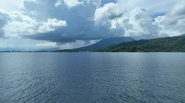 Clouds drift above Lembeh Strait, separating North Sulawesi from Lembeh Island. This tropical area is home to a plethora of marine biodiversity and is popular among divers.