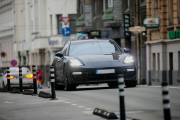 Fototapeta premium Luxury sports car driving on city center road in fast motion for a expensive lifestyle