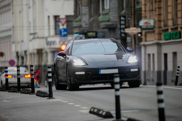 Luxury sports car driving on city center road in fast motion for a expensive lifestyle