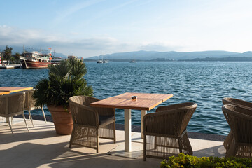 Obraz premium Waterfront Dining with Stunning Coastal Views. Seascape view from cafe for nature lovers, travel websites, or background for relaxation and tranquility. High quality photography