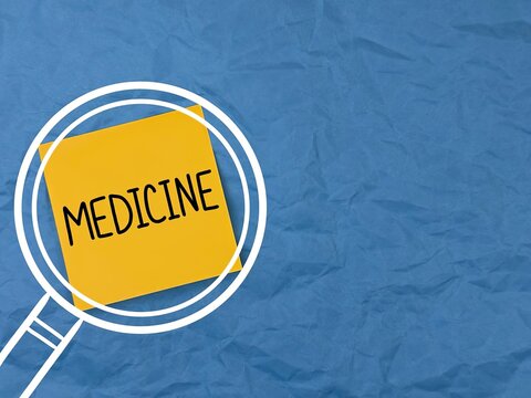 the inscription medicine. the hand is holding paper, and medicine is written on the paper. banner for advertising medical services. the inscription medicine on a paper background.