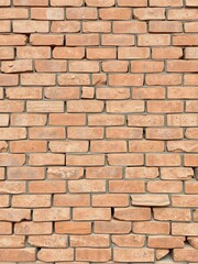 Aged weathered brick wall, showing signs of wear and crumbled stones, rough, building