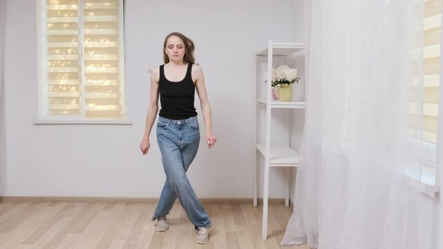 Young woman practicing hip hop dance moves in slow motion, showcasing energy, style, and expression in a studio setting