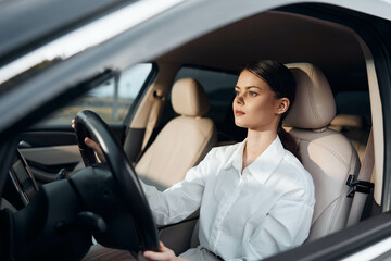 Woman driving car a woman sits confidently in the driver's seat of a vehicle, her hand resting on...