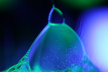 Bright purple reflection of liquid on black background, blur colours, surrealistic background, fantastic smooth movement, bright glossy surface