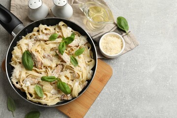 Delicious pasta Alfredo with chicken served on grey table, flat lay. Space for text © New Africa