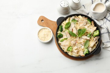 Delicious pasta Alfredo with chicken served on white marble table, flat lay. Space for text © New Africa