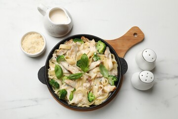 Delicious pasta Alfredo with chicken served on white marble table, flat lay © New Africa