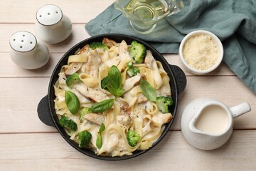 Delicious pasta Alfredo with chicken served on wooden table, flat lay © New Africa