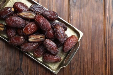 Many tasty dried dates on wooden table, top view. Space for text © New Africa