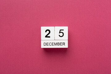 Calendar with date December 25 on color background, top view