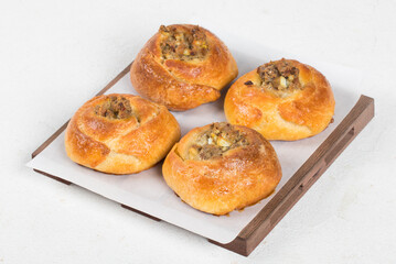 Open pie filled with fish, eggs and onions. White background. On a wooden stand