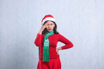 portrait of beautiful female wearing christmas sweater, Santa hat and scarf, messy looking at...