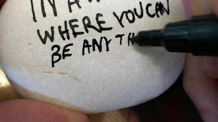 Writing be kind message on kindness rock