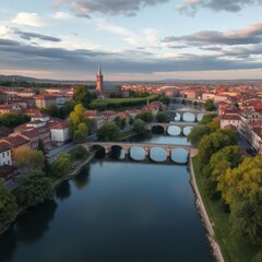 Aerial view of a historic European city, winding river with multiple stone bridges, medieval architecture, gothic cathedral spire, terracotta rooftops, lush green trees, golden evening light, dramatic