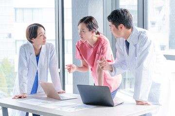 Obraz premium パソコンを使って会議をする医師、看護師