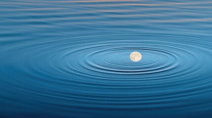 Serene moon reflection on calm water with concentric ripples.
