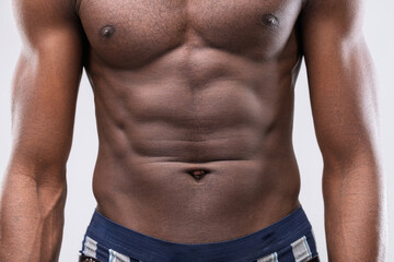 Muscular black man showing his defined abs and chest