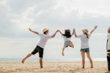 Happy family three hand in hand and jumping on sandy beach, Parents father and mother jump their children back car, holiday vacations summer road trip, Family day enjoying their time together