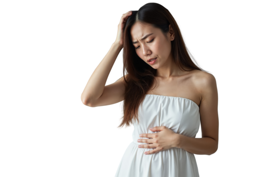 young Asian woman with shoulder-length brown hair, wearing a white strapless dress, standing against a beige wall, looking distressed.