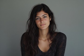 Fototapeta premium Natural Portrait of a Young Woman with Long Hair Against a Neutral Background