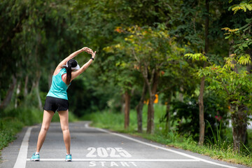 The start into the new year 2025. Start up of runner woman running on nature race track go to Goal...