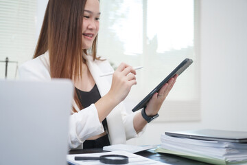 A young, professional businesswoman working at her desk in an office, providing online legal...