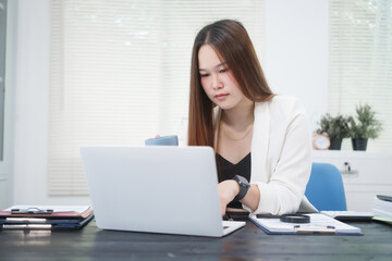 Fototapeta premium A young, professional businesswoman working at her desk in an office, providing online legal consultancy for disputed civil cases, addressing lawsuits, loan defaults, unfair dismissals, and property