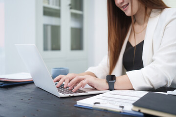 A young, professional businesswoman working at her desk in an office, providing online legal...