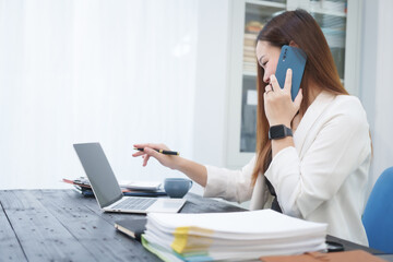 A young, professional businesswoman working at her desk in an office, providing online legal...