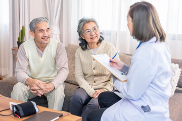 Obraz premium asian senior couple giving a health interview to a home visiting nurse, a young female health care personnel taking a patient data notes on flip chart paper