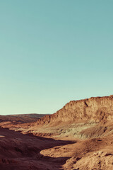 Naklejka premium Majestic desert landscape at sunset showcasing rocky cliffs and expansive sky