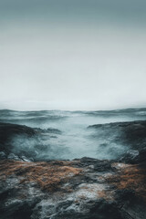 Obraz premium Misty landscape at dawn with rocky terrain and low-lying fog