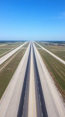 Fototapeta premium Aerial view of a long, straight runway at an airport on a clear sunny day.