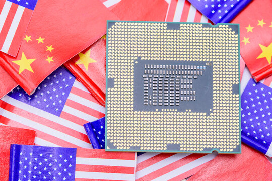 US-China tech competition : The semiconductor showdown. A computer processor lies atop flags of the United states and China, symbolizing themes of trade war, technology rivalry, and security concerns.