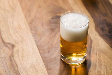 light beer in glass on wood background with copy space