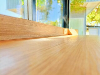 Empty wooden table in coffee shop with sunlight and bokeh background.