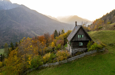 Wooden mountain hut overlooking autumn valley in the julian alps, slovenia.