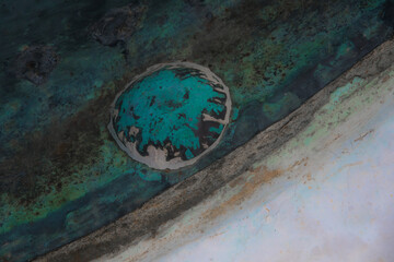 Dettaglio di un bullone alla base di una botola di rame ossidata e diventata verde