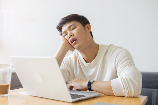 close up young employee man take a nap in the day feeling lazy and sleepy after break time at office , lifestyle people concept
