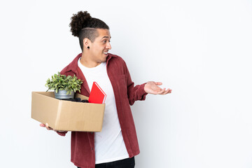 Caucasian man making a move while picking up a box full of things over isolated white background...