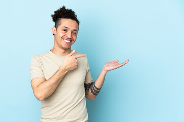 Caucasian man over isolated background holding copyspace imaginary on the palm to insert an ad